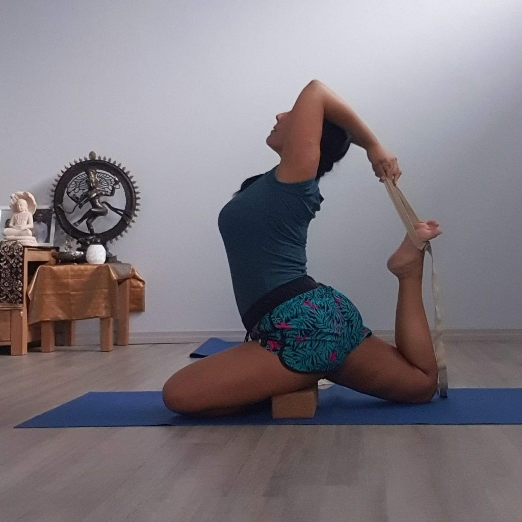L'insegnante certificata Beatrice Canu esegue una variante avanzata della posizione del Piccione Reale con cinghia e mattoncino presso Kalishiva Yoga Torino