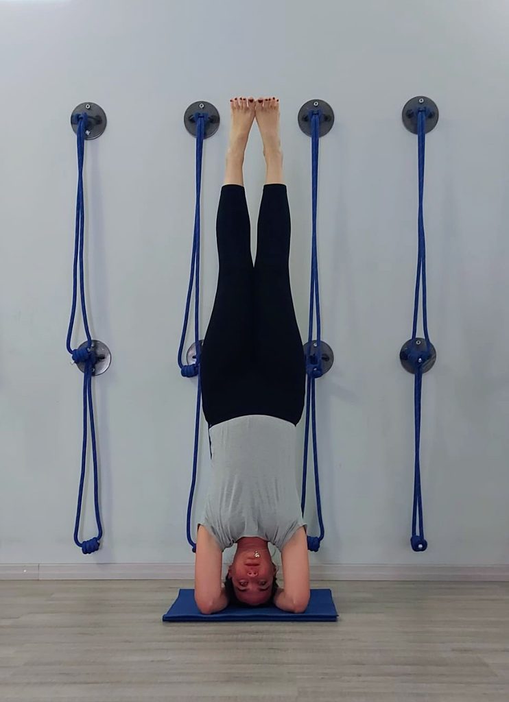 L'insegnante di yoga Erika Beltrame esegue la posizione capovolta Sirsasana nella sala attrezzata della scuola Kalishiva Yoga a Torino