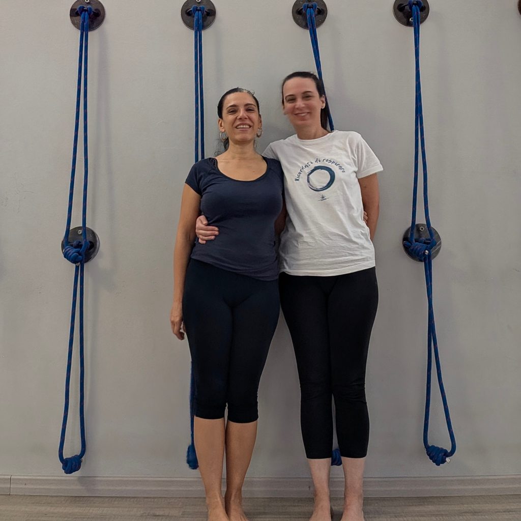 Le insegnanti di yoga a Torino Beatrice Canu e Erika Beltrame sorridenti davanti alla parete con corde della scuola Kalishiva Yoga